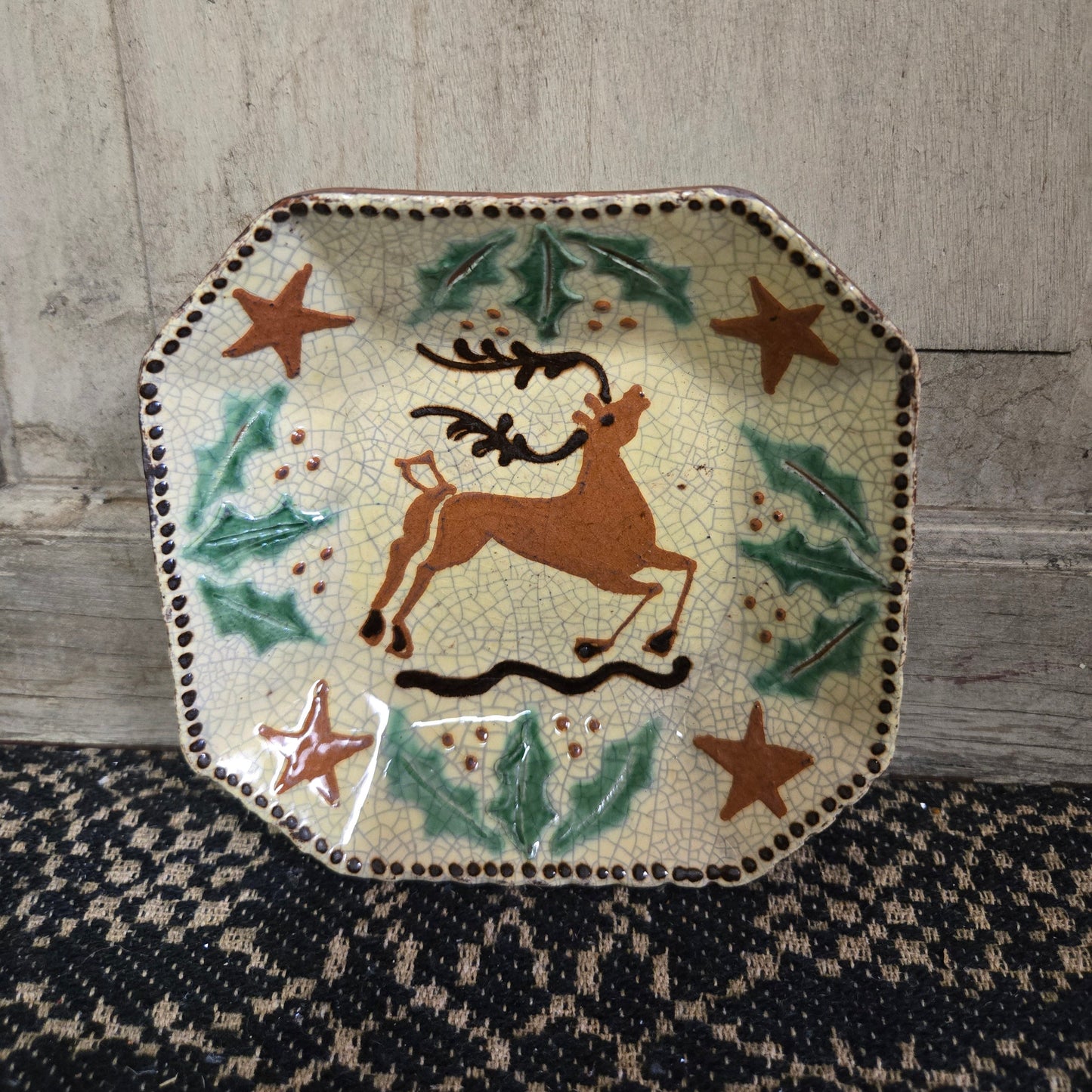 Octagonal redware plate with stag, holly and stars motif