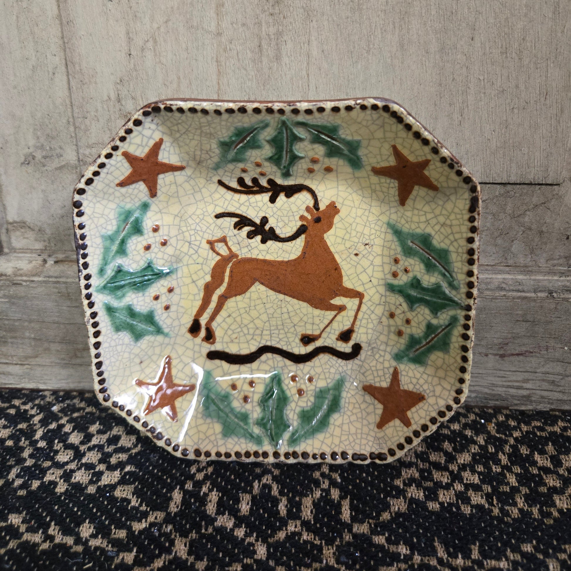 Octagonal redware plate with stag, holly and stars motif