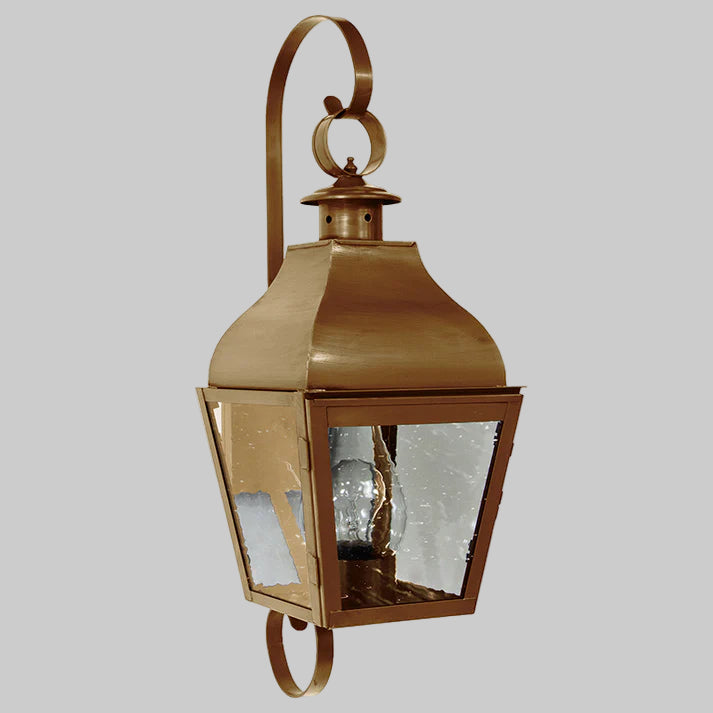 Bronze outdoor wall lantern with clear glass on a white background