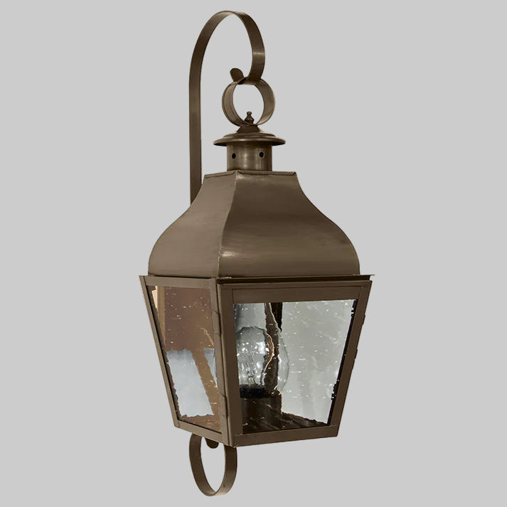 Bronze outdoor wall lantern with glass cover on a white background