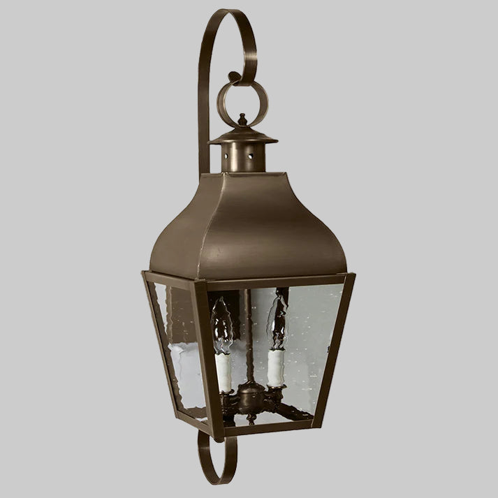 Bronze outdoor wall lantern with clear glass on a white background