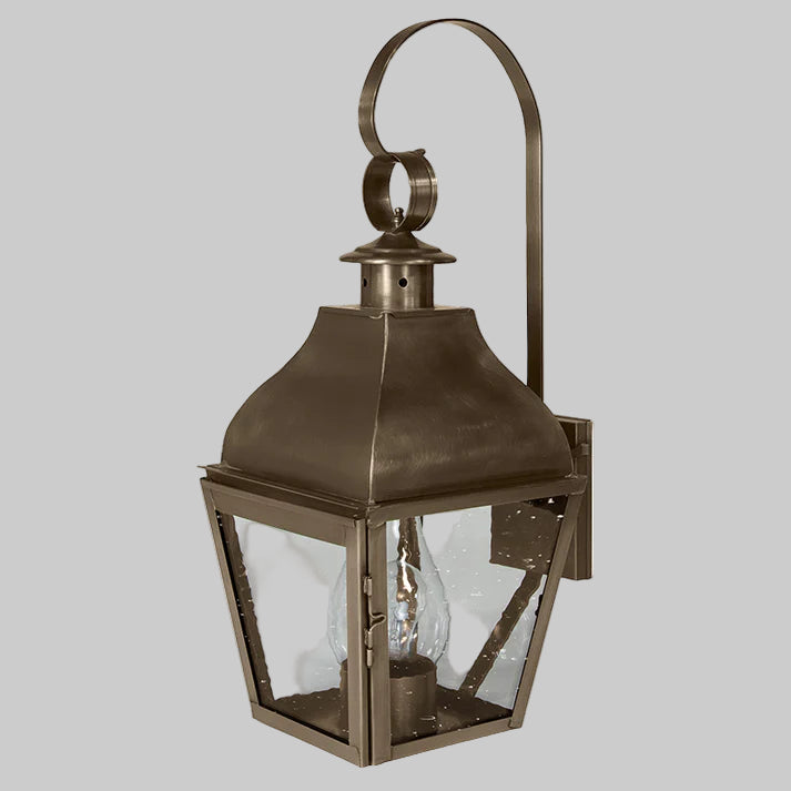 Bronze outdoor wall lantern with clear glass on a white background