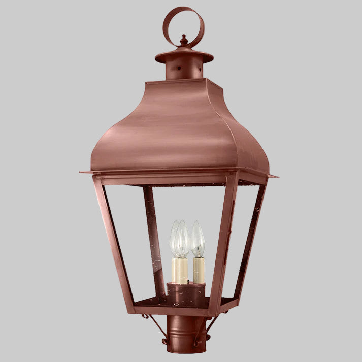 Bronze outdoor lantern with two visible light bulbs on a gray background