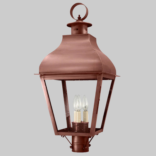 Bronze outdoor lantern with two visible light bulbs on a gray background