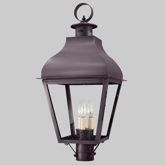 Dark metal outdoor lantern with two visible light bulbs on a gray background