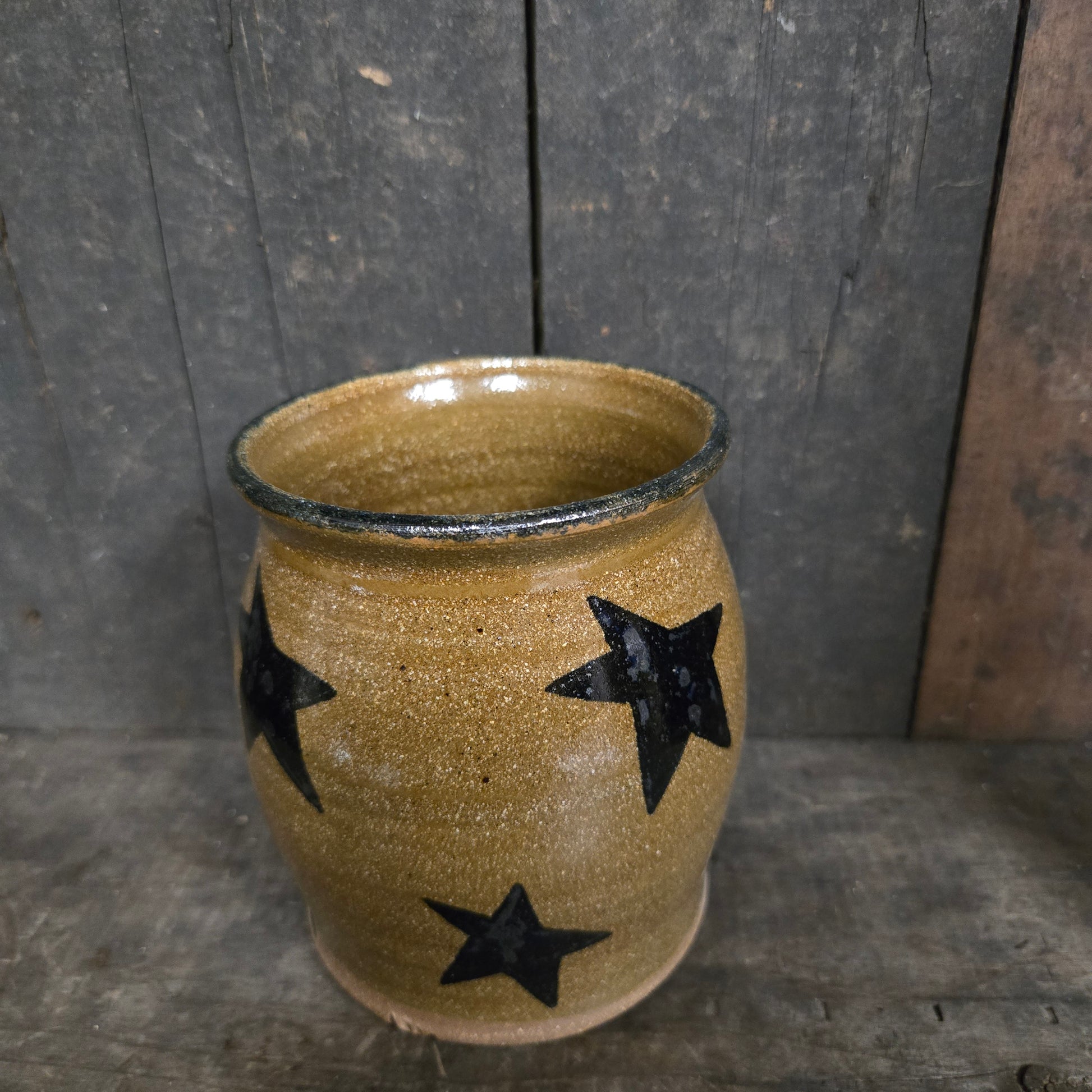 Ceramic cup with black star designs on a wooden surface