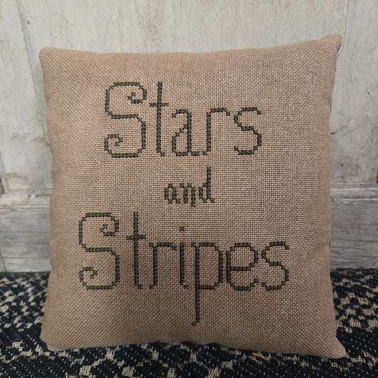 Decorative pillow with 'Stars and Stripes' text on a textured background.