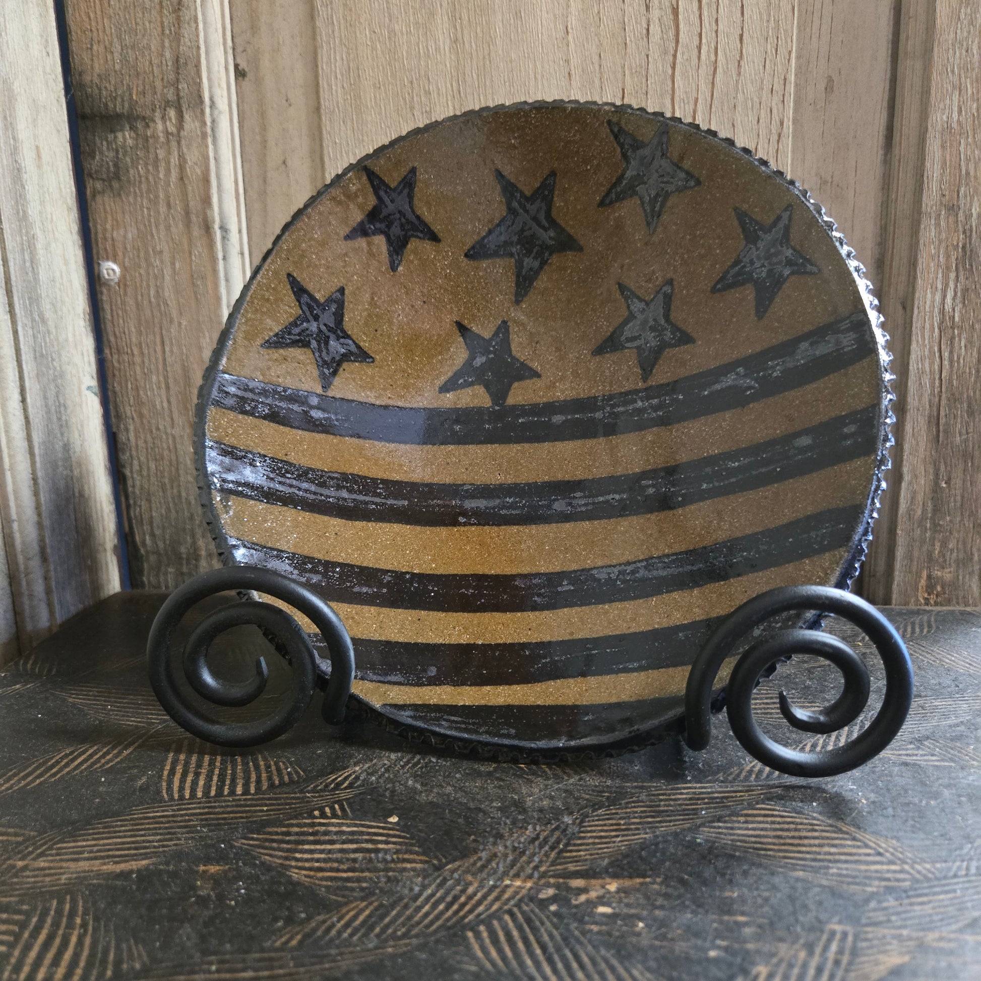 Decorative stoneware plate with stars ands stripes pattern on a wooden background
