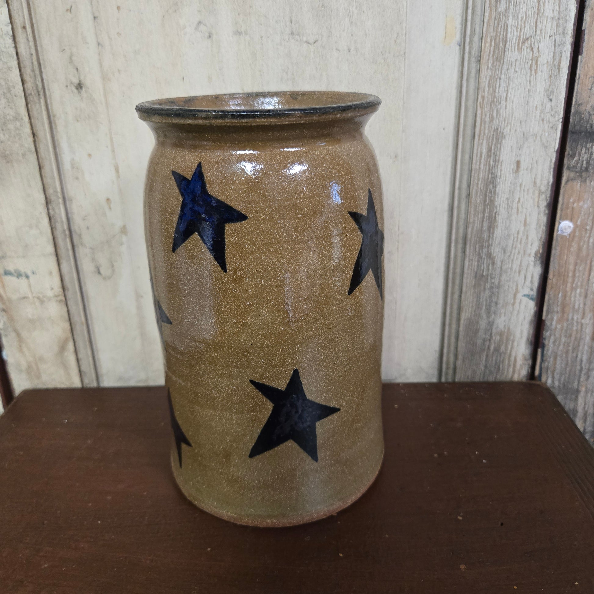 Ceramic vase with star patterns on a wooden surface