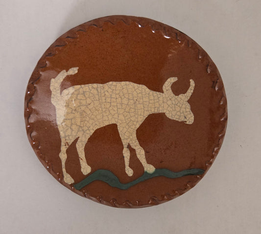 Small round redware plate with a steer motif