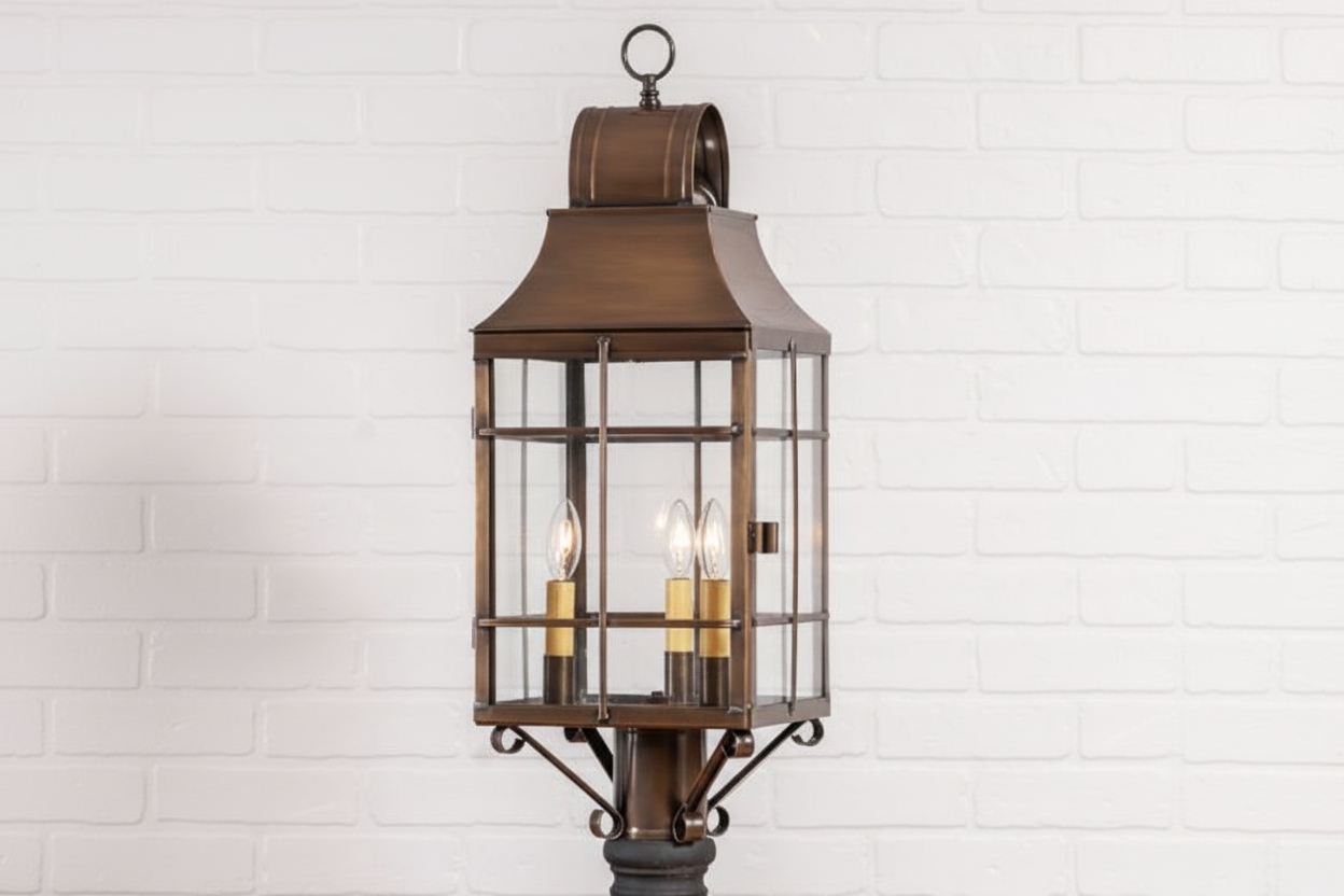 Bronze outdoor lantern with glass panels on a white tiled wall background
