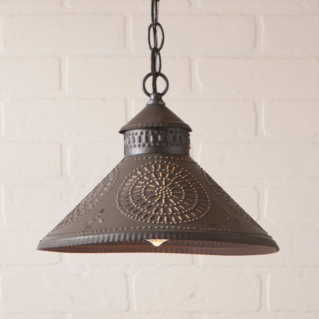 Decorative pendant light with intricate design on a white brick wall background