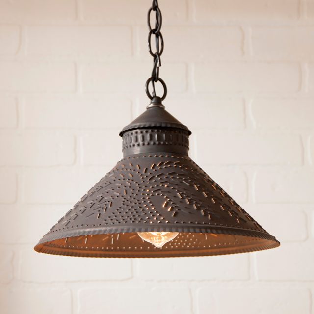 Decorative pendant light with intricate design on a white brick wall background