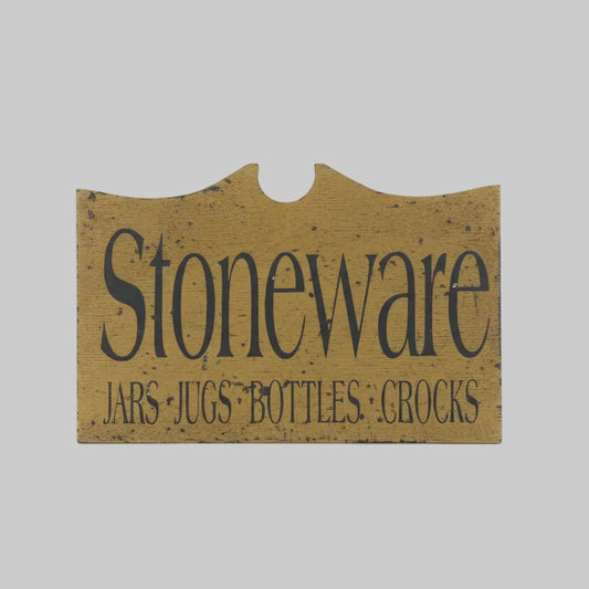 Sign with 'Stoneware Jars, Jugs, Bottles, Crocks' text on a wooden background