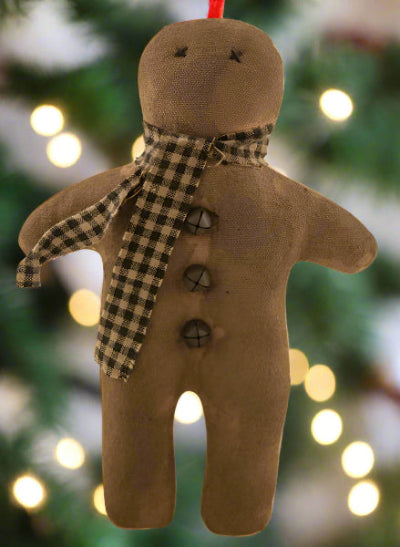 Stuffed gingerbread man wearing checked scarf on white background
