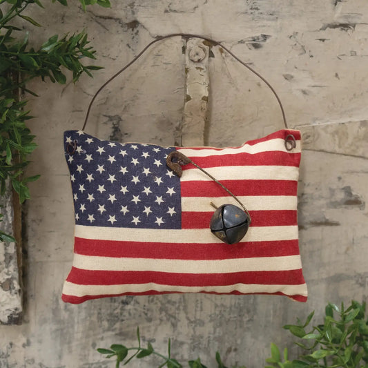 Flag ornament with rusty bell on wooden door