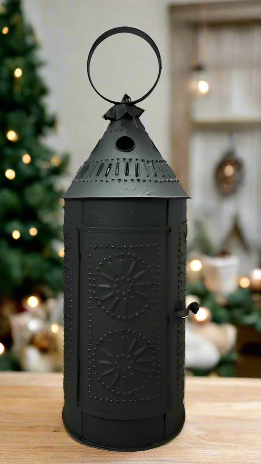 A black textured metal lantern with a traditional design, featuring a top handle and a front latch, intended for holding a battery operated taper candle.