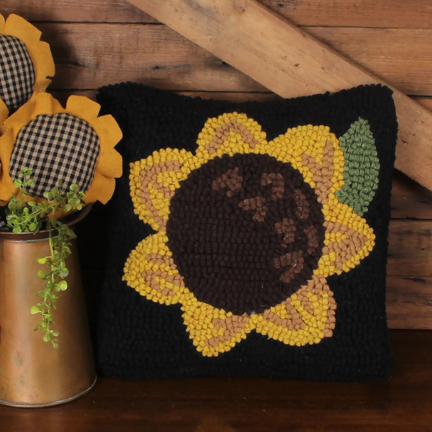 Decorative pillow with sunflower design on a wooden surface