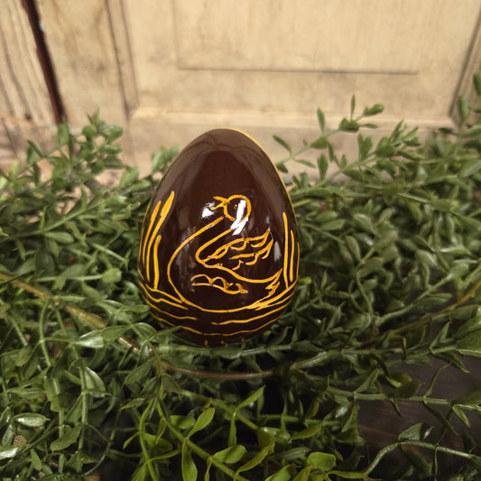 Brown redware egg with yellow glaze swan and reed motif