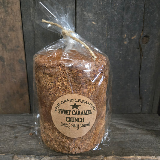 Wrapped sweet caramel crunch candle on a wood surface.