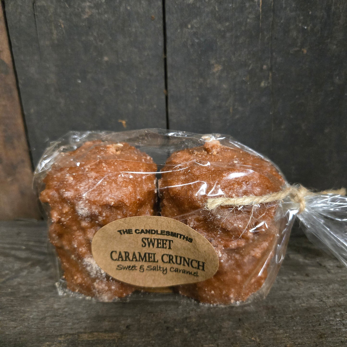 Packaged caramel crunch candles with a label on a wooden surface