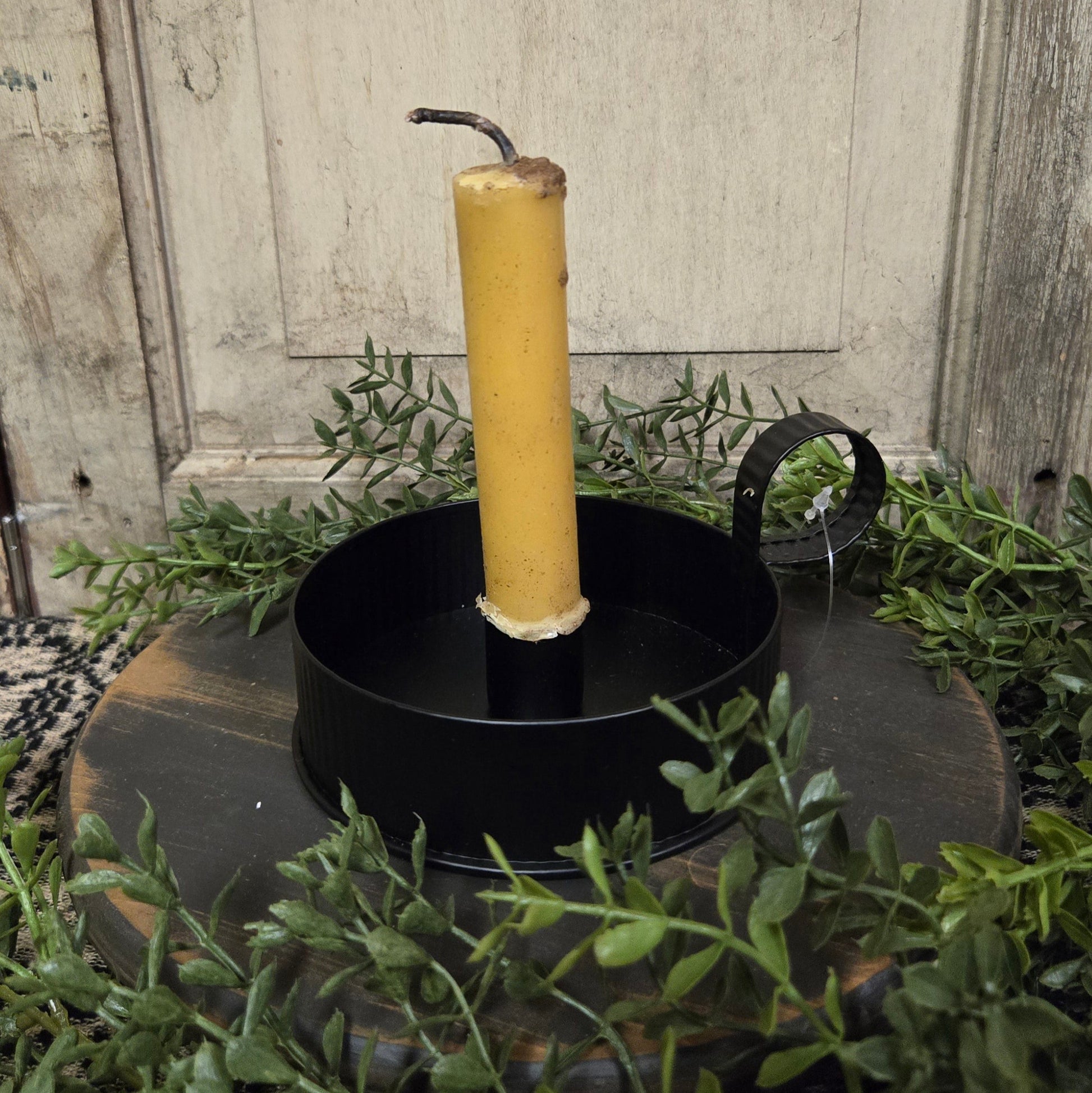 Candle pan with beeswax candle on textured black riser