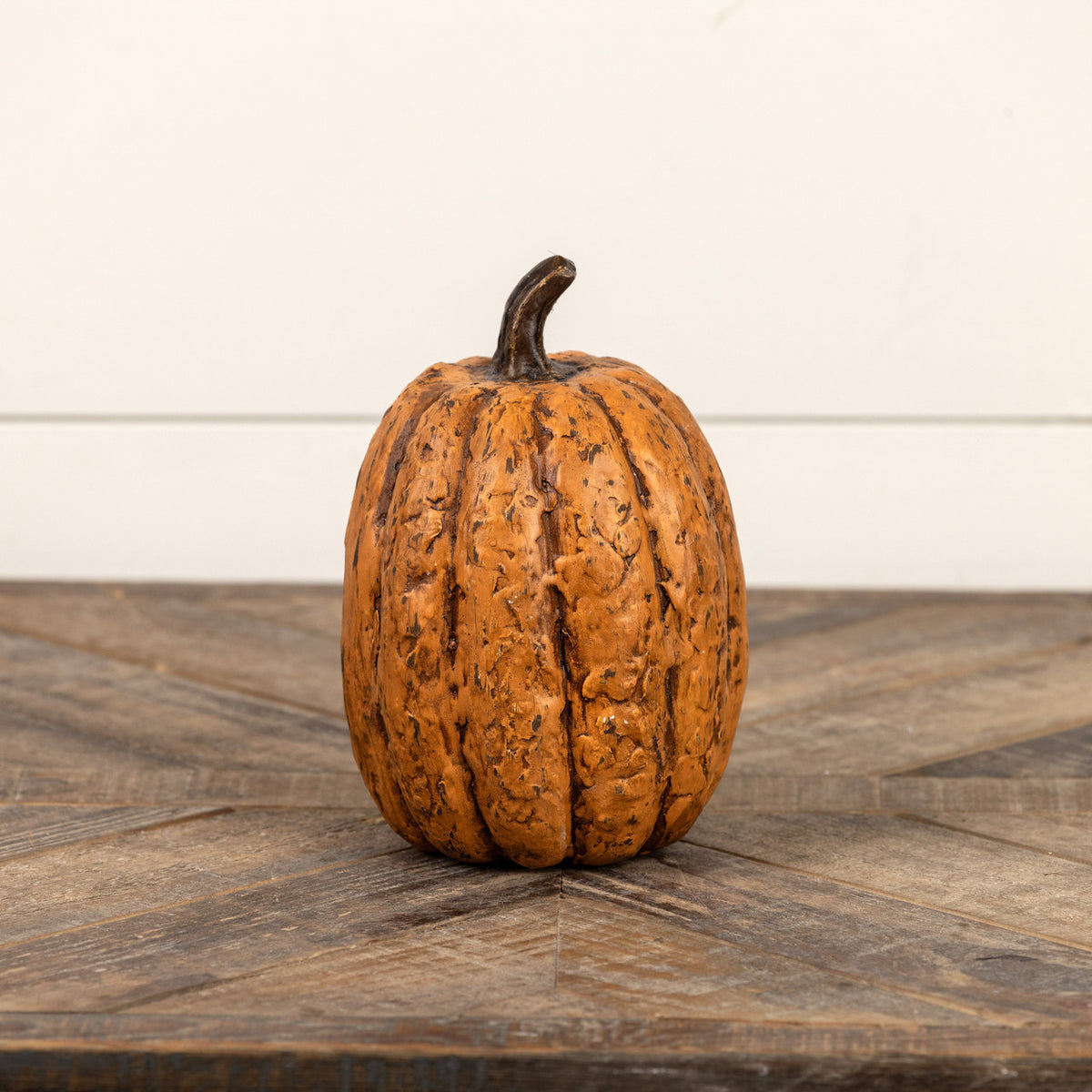Small pumpkin on a wooden surface with a white background