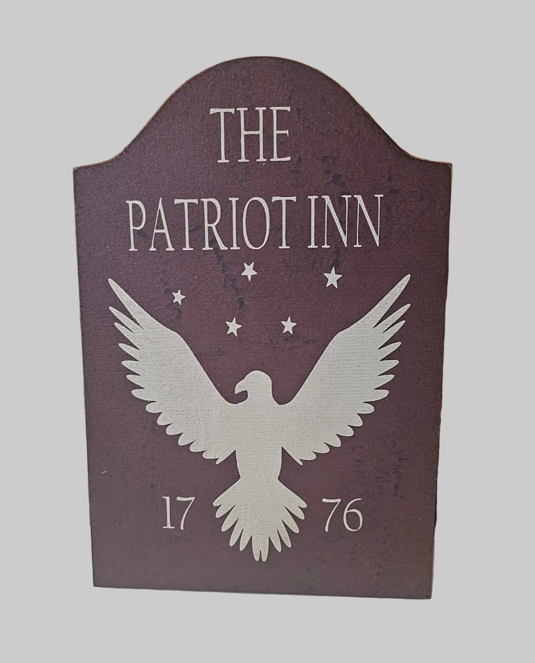 Decorative sign with 'The Patriot Inn' and an eagle silhouette on a wooden background