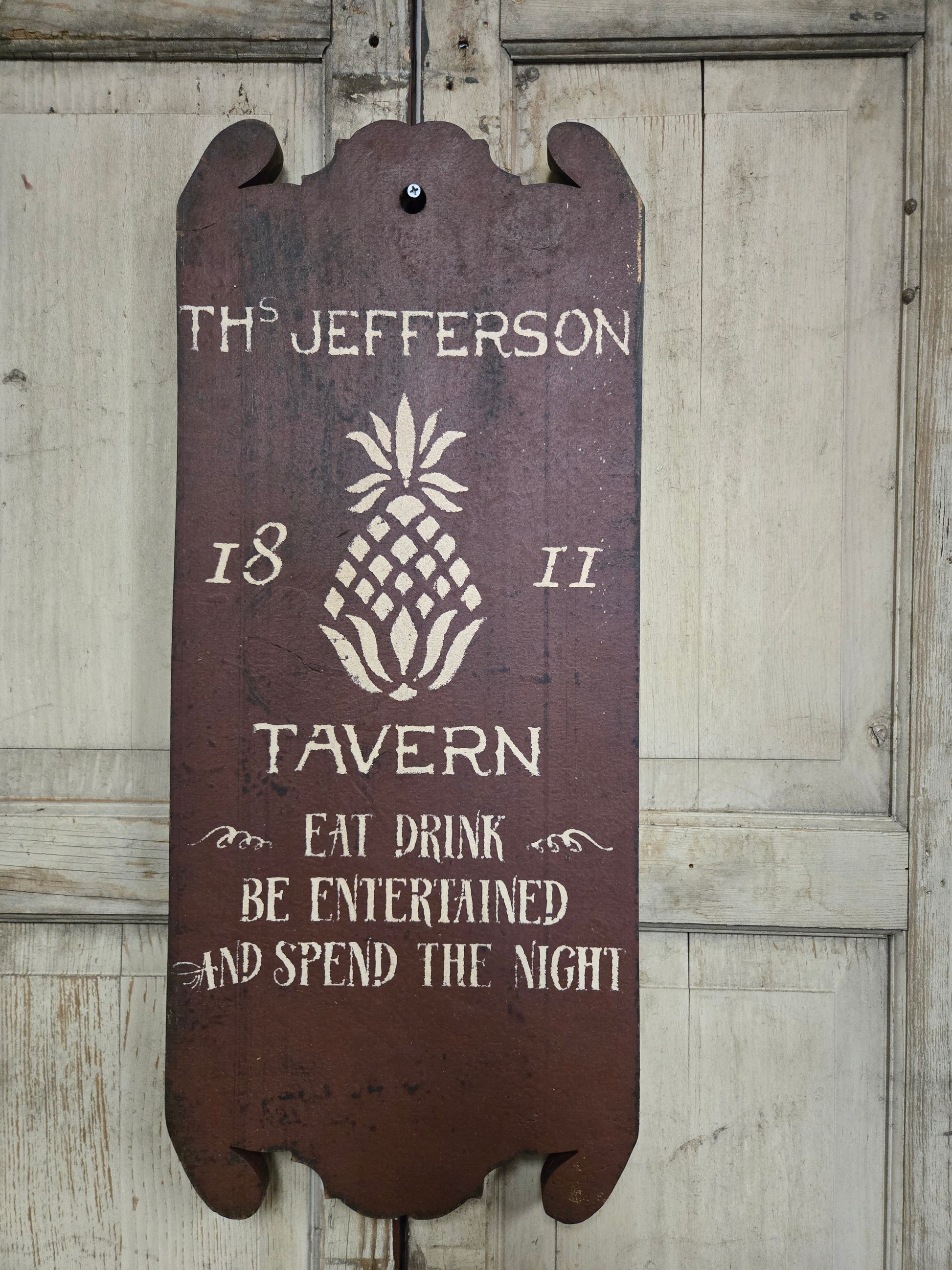 Wooden sign with text and pineapple design on a wooden background