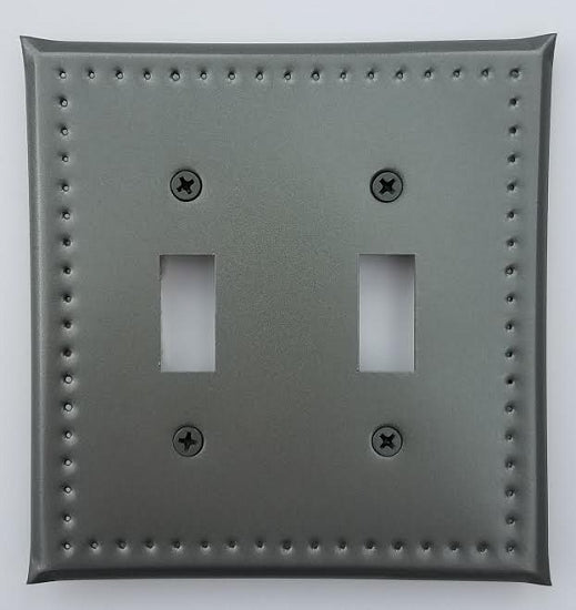 A gray double switch plate border punch with a decorative dotted border design around the two switches.
