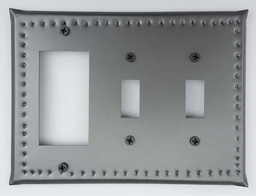 Decorative metal switch plate with rivet details on a white background