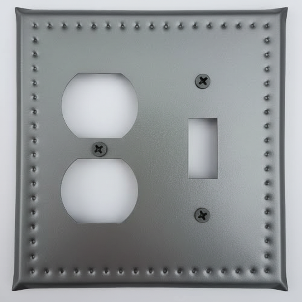 Metallic switch plate with two outlets and a switch on a light gray background