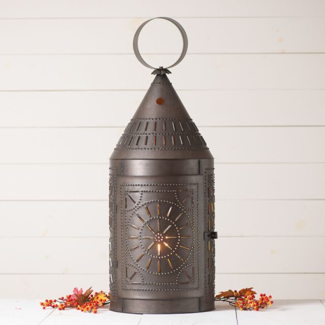 Punched tin lantern with bittersweet twigs on a white background.