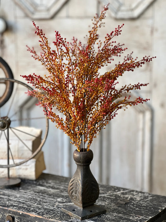 A faux Torchlight berries arrangement in a brown metal vase with shades of orange and yellow flowers.