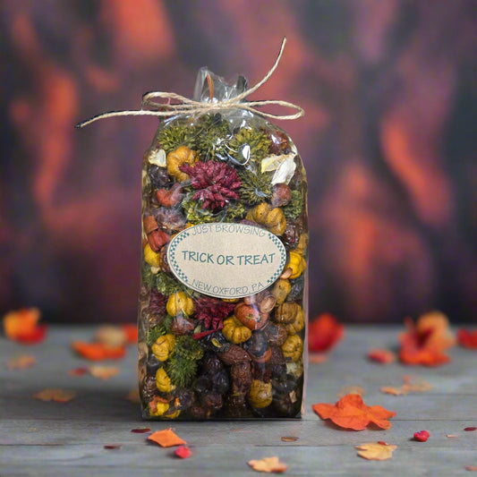 Decorative box with potpourri surrounded by autumn leaves on a dark background