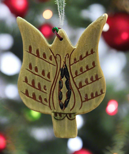 Decorative angel ornament with intricate patterns on a blurred Christmas tree background