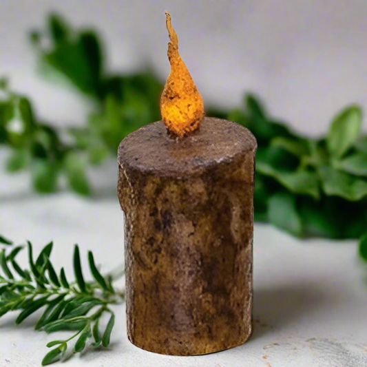 Decorative candle with a rustic base and glowing top on a white background