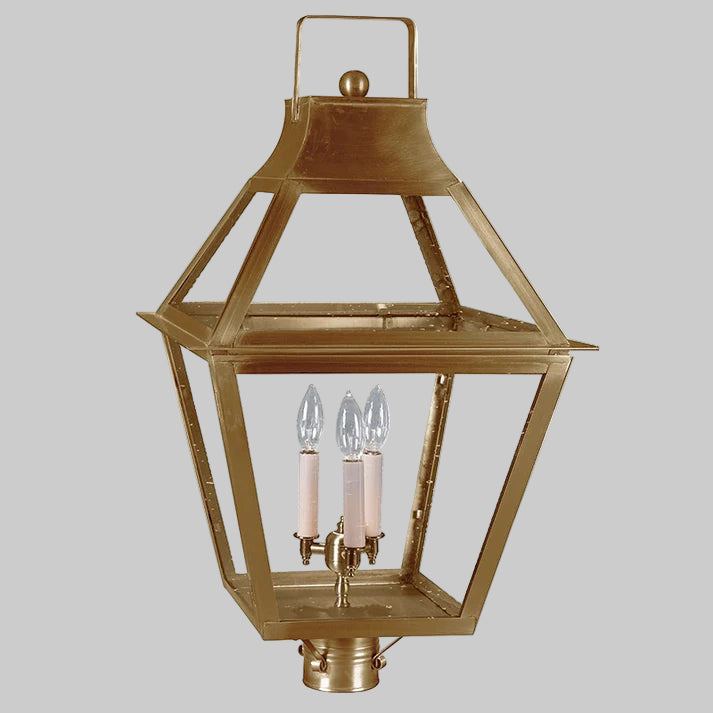 Brass post lantern with three candle-like lights on a gray background