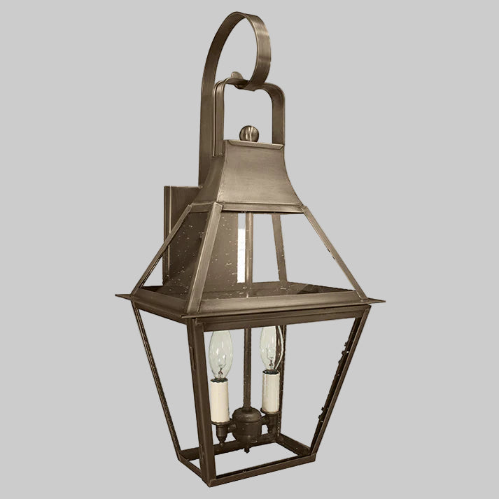 Bronze outdoor wall lantern with two light bulbs on a gray background