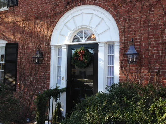 Two wall light fixtures flanking a door on brick.