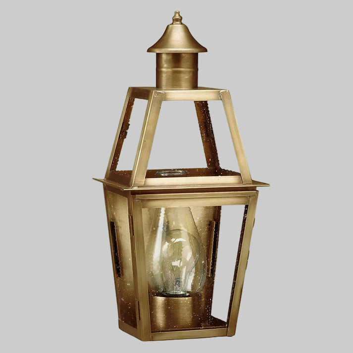 Brass outdoor lantern with clear glass on a gray background