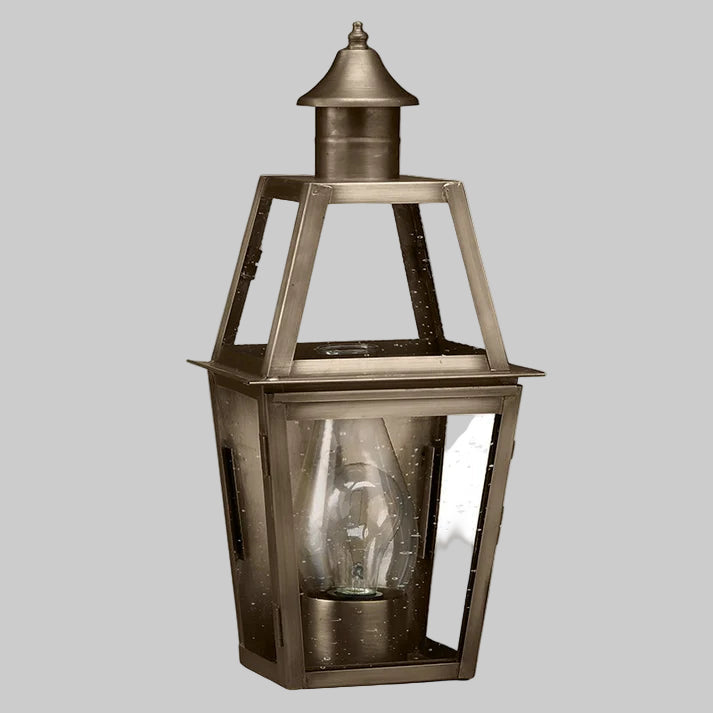 Brass outdoor lantern with clear glass on a white background