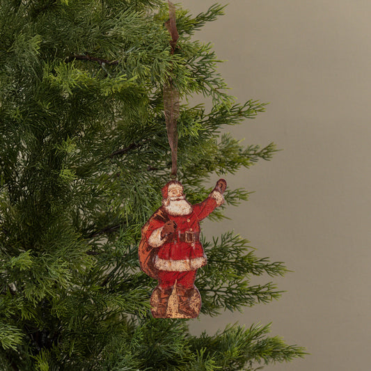 Decorative Santa Claus ornament hanging on a Christmas tree branch.