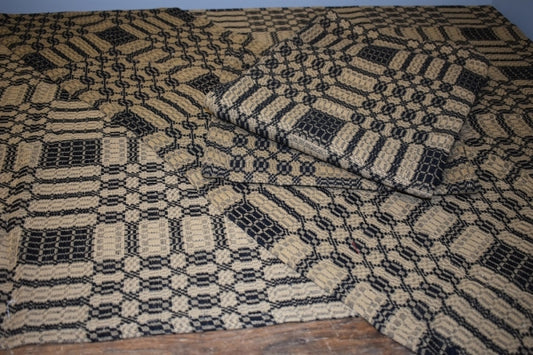 A folded black and tan table square with a geometric pattern.