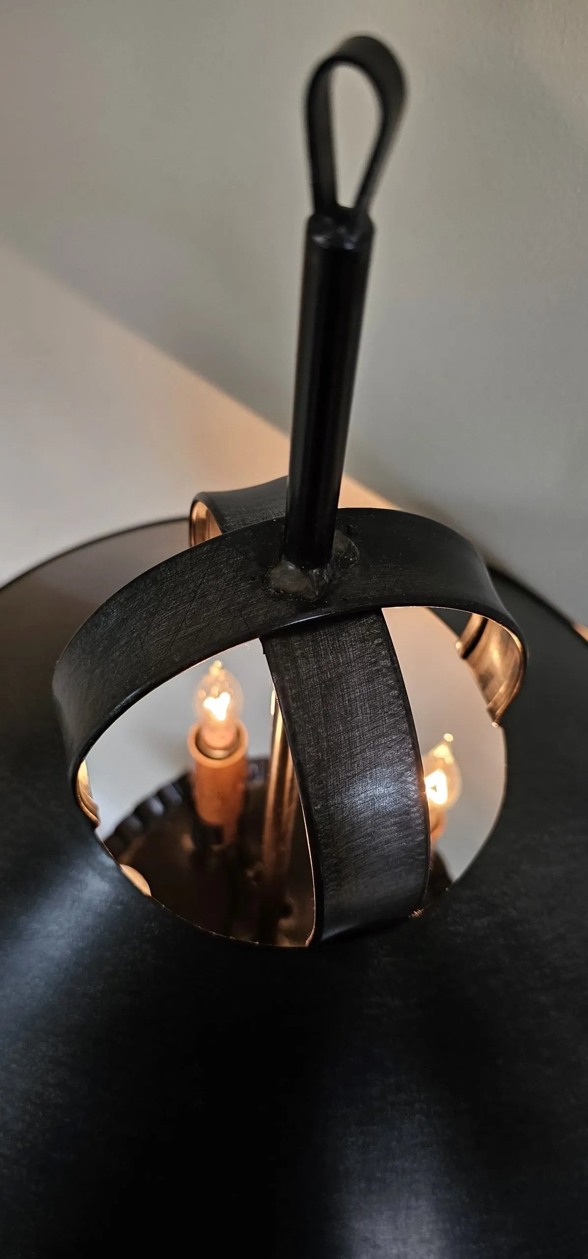 Decorative candle holder with black and gold design on a dark surface.