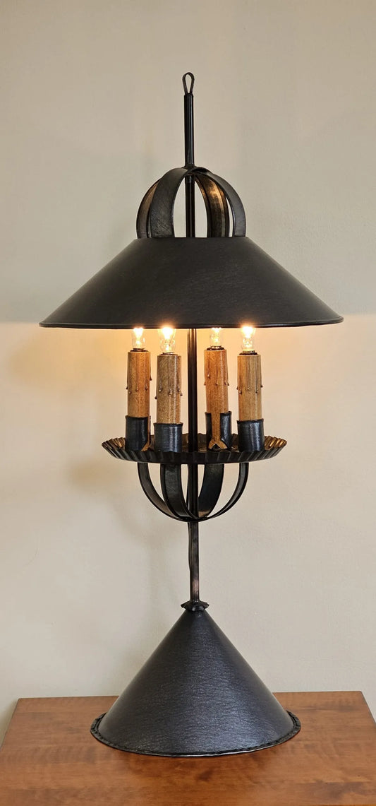 Decorative black metal lamp with multiple candle-like lights on a wooden surface.