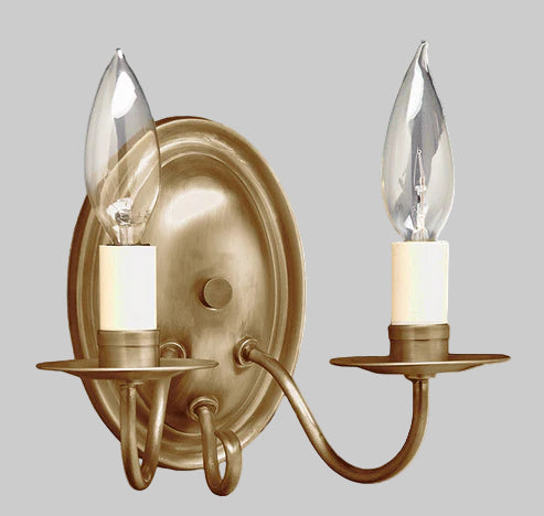 Gold wall sconce with two candle-style lights on a gray background