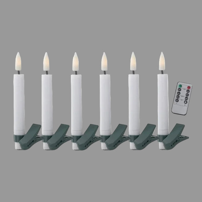 A set of six white LED tree clip candles with green clips and a remote control.