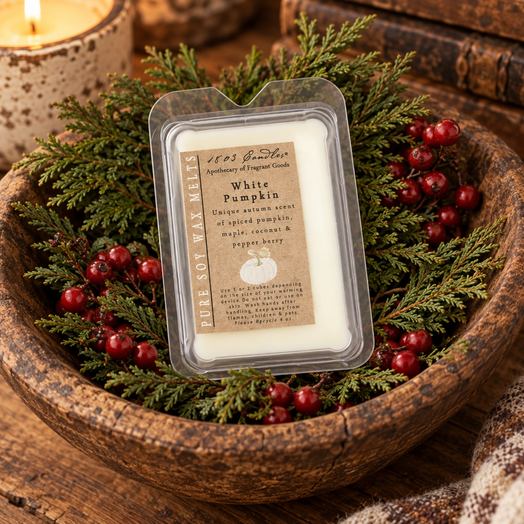 A clear plastic tub of pure soy wax melts labeled 'White Pumpkin' by 1853 Scents, styled in a rustic wooden bowl with green pine branches and red berries.