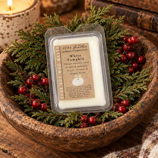 A clear plastic tub of pure soy wax melts labeled 'White Pumpkin' by 1853 Scents, styled in a rustic wooden bowl with green pine branches and red berries.